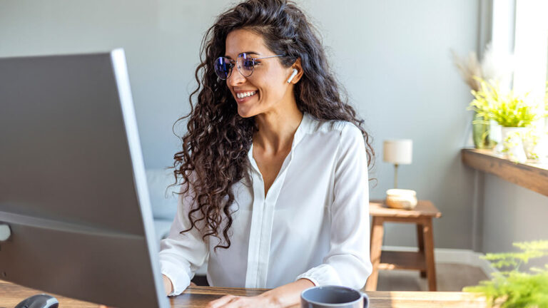 Woman smiling at her computer.