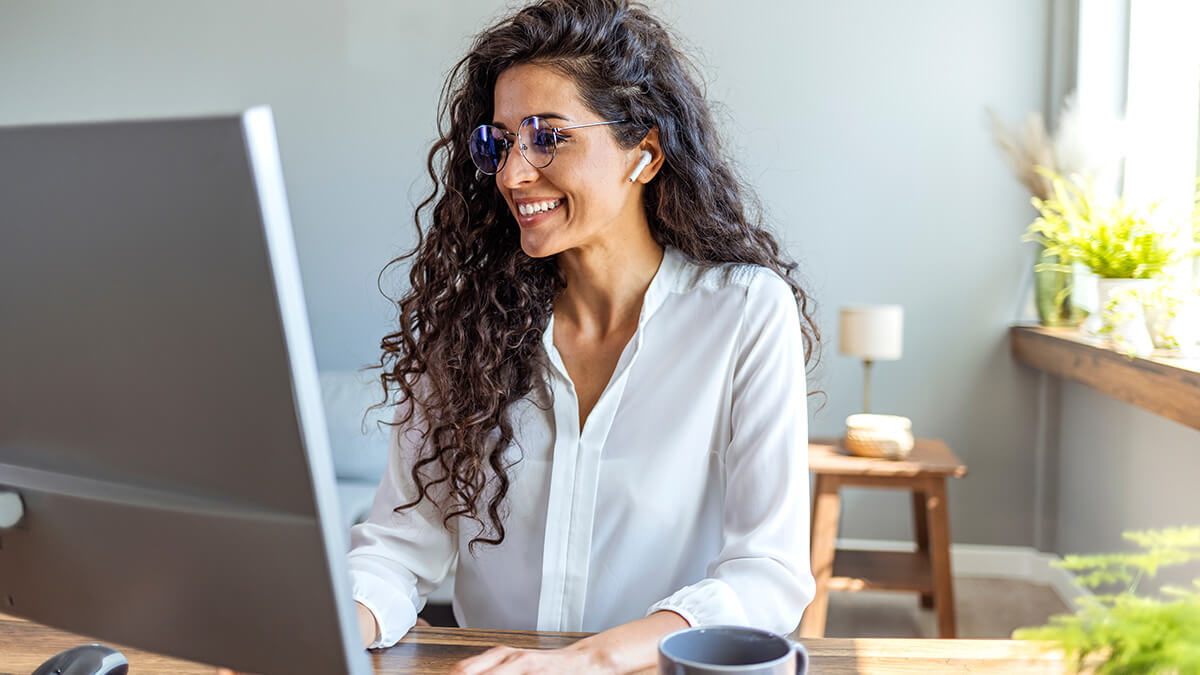 Woman smiling at her computer.