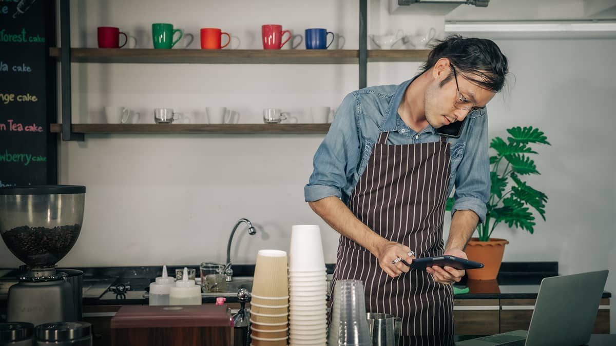 Man calculating the break-even point for his coffee house.