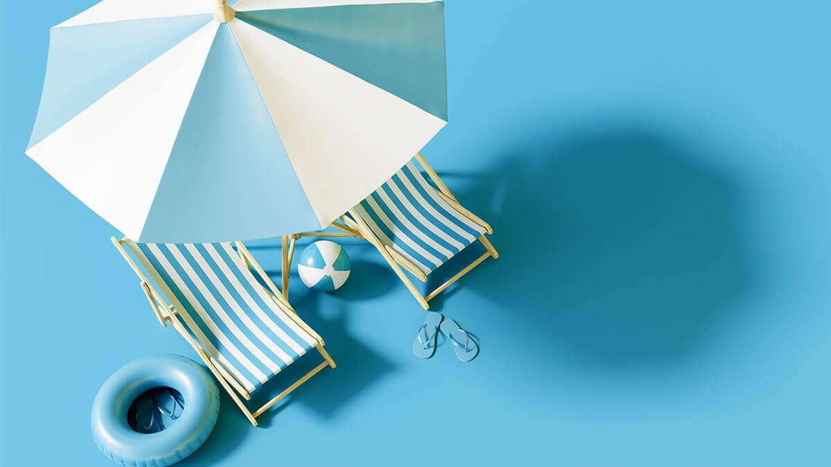 Two miniature beach chairs under an umbrella.
