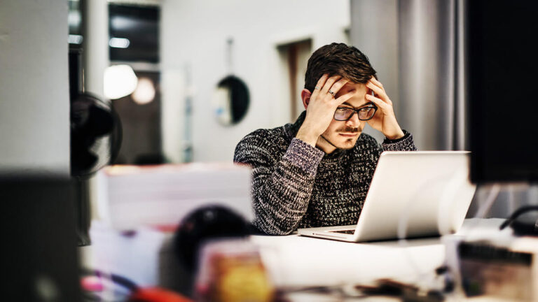 Stressed man with hands on his head.