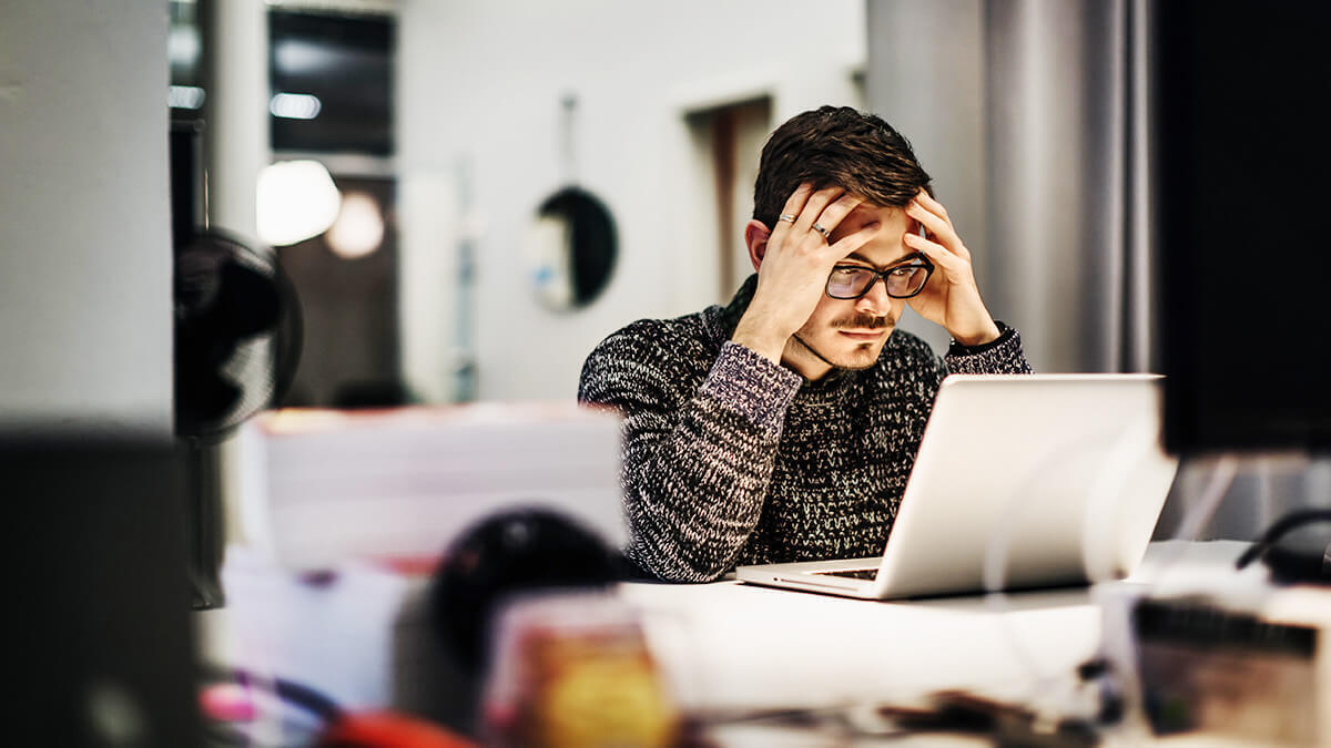 Stressed man with hands on his head.