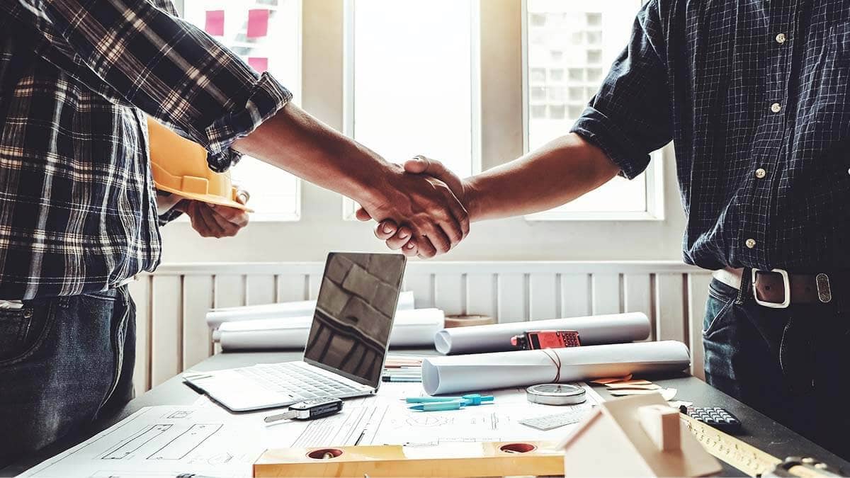 Contractor and business owner shaking hands.