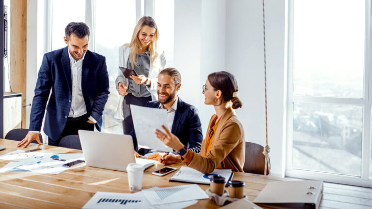 Four professionals working together in a meeting room.