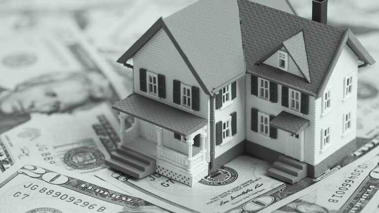 Miniature house on bills.