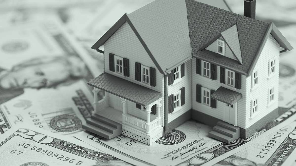 Miniature house on bills.