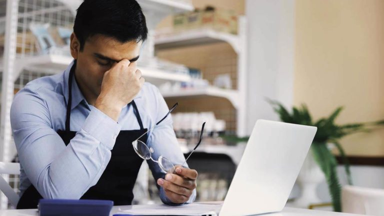 Stressed man holding the bridge of his nose.