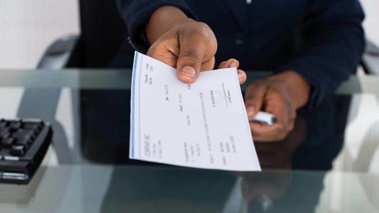 Employer handing a paycheck to an employee.