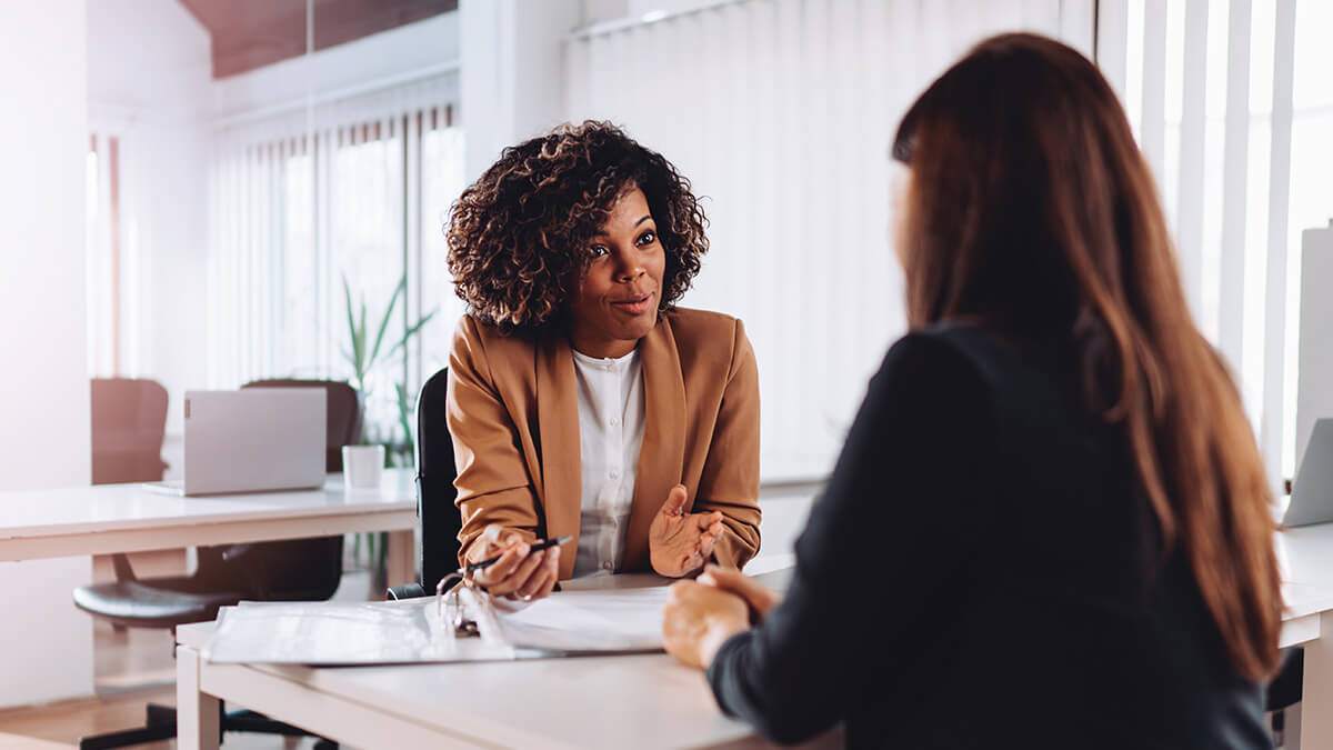 Two women talking about outsourcing payroll.