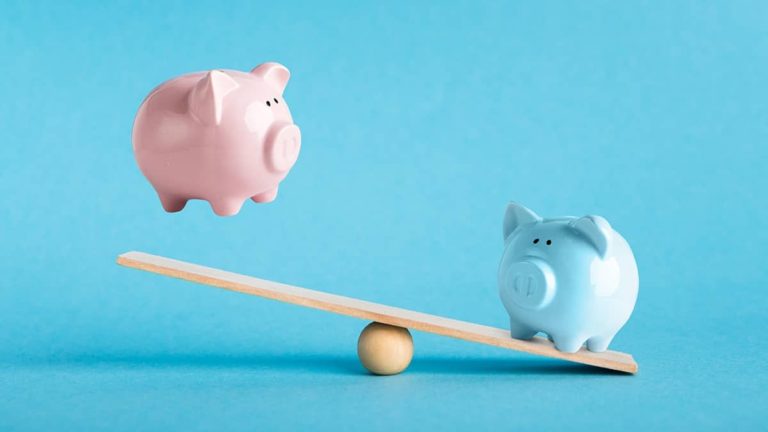 A pink and blue piggy bank on a seesaw.
