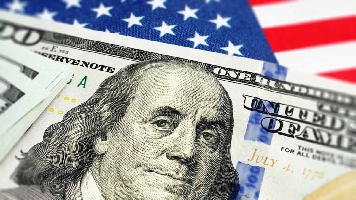 $100 bill with American flag in the background.