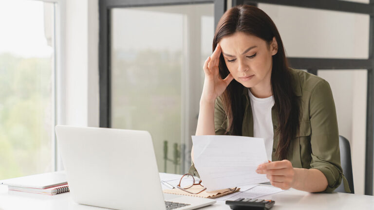 Stressed woman looking at business loss information.