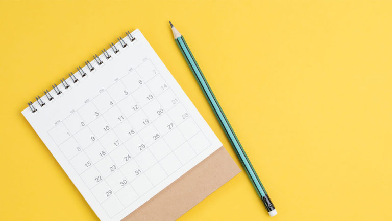 Calendar on a yellow background with a pencil.