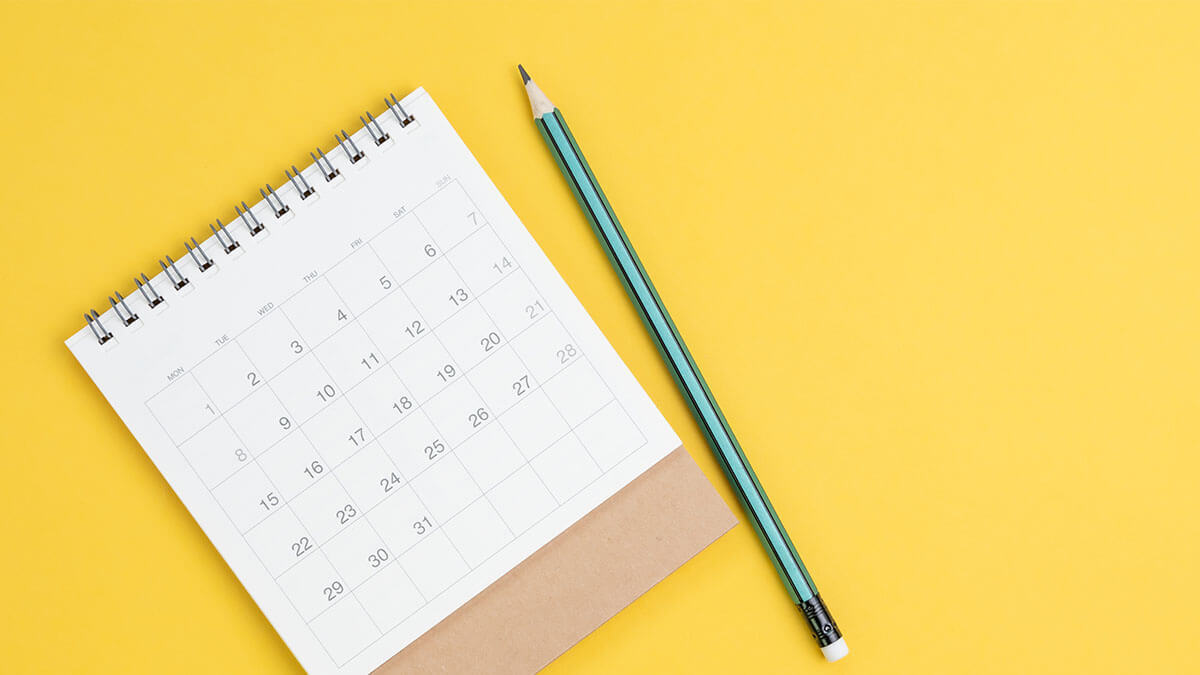 Calendar on a yellow background with a pencil.