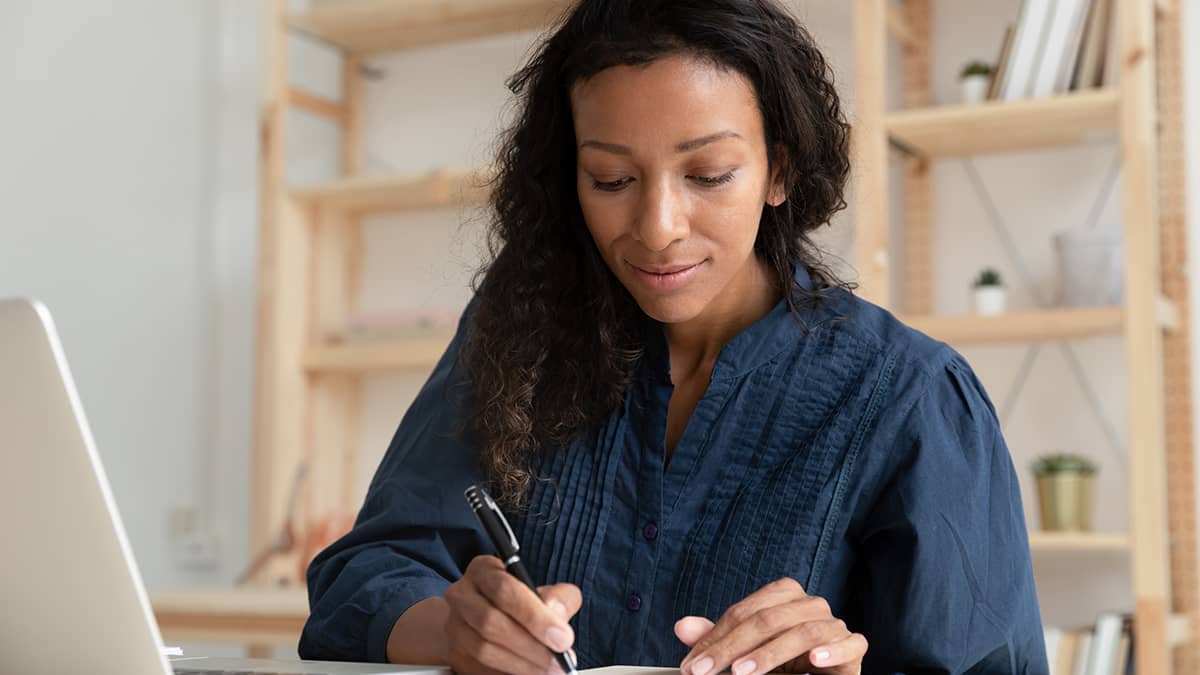 Woman filling out Form 941-X.
