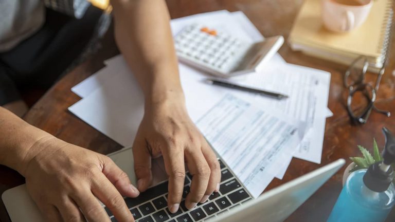 Business owner typing on a laptop.