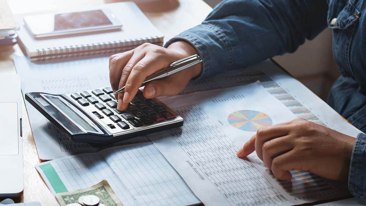 Business owner typing numbers into a calculator.