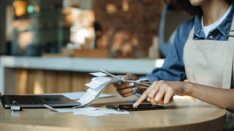 Business owner with a stack of receipts.