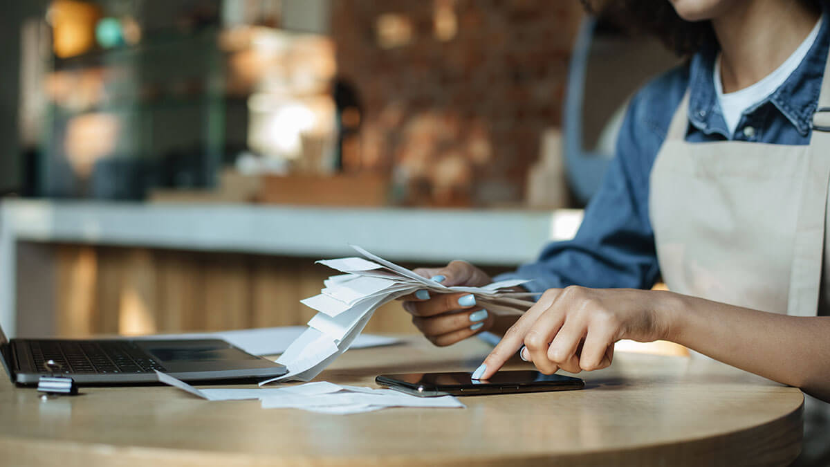 Business owner with a stack of receipts.