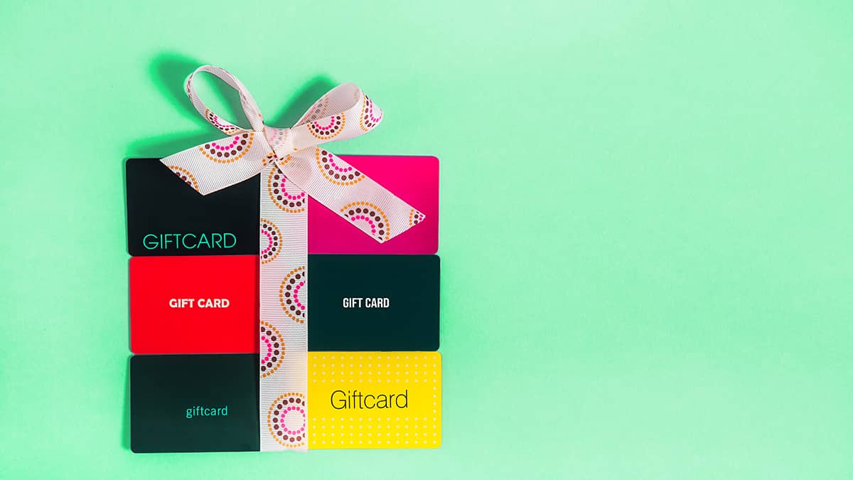 Six gift cards in the shape of a small box tied up in a bow.