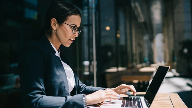 Woman typing on a laptop.