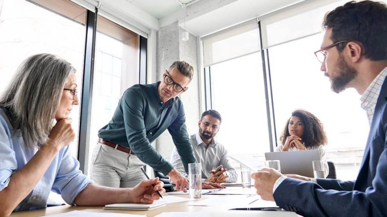 Team of professionals discussing group-term life insurance benefits.