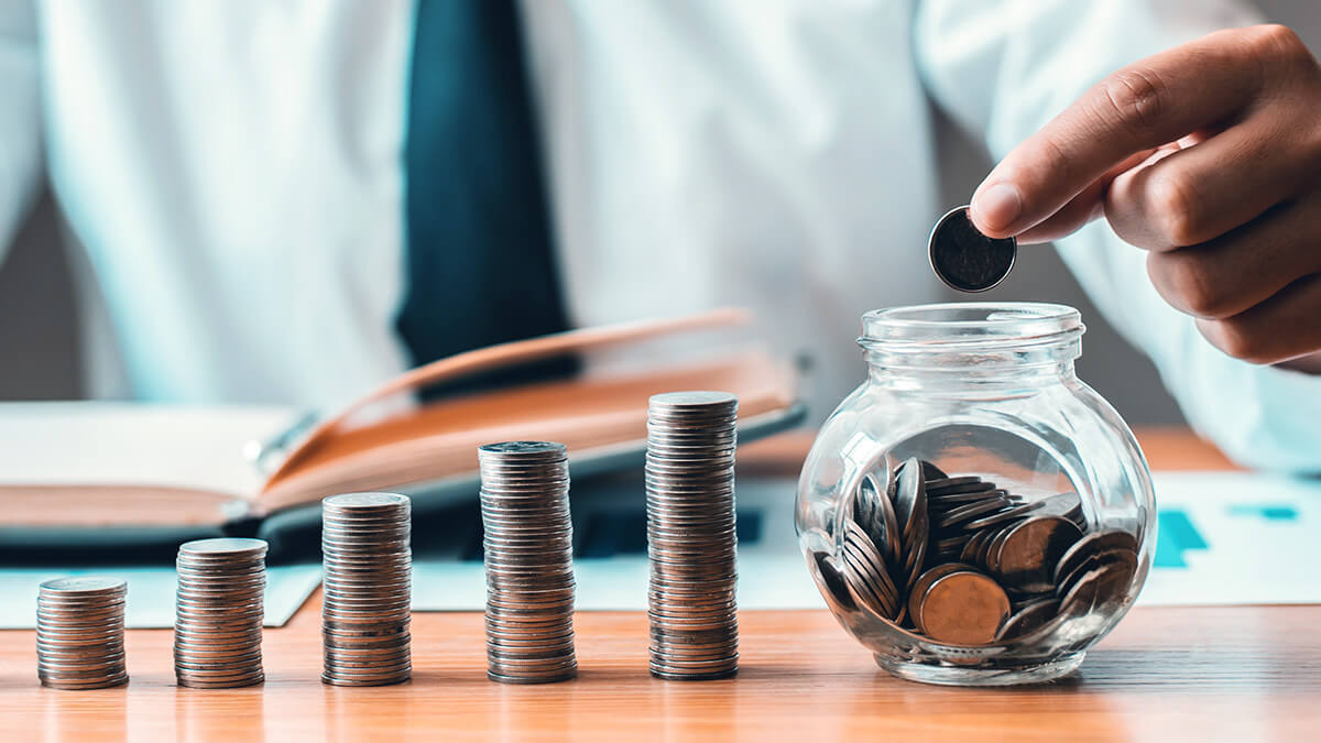 Man with ascending piles of coins dropping them into a glass jar.