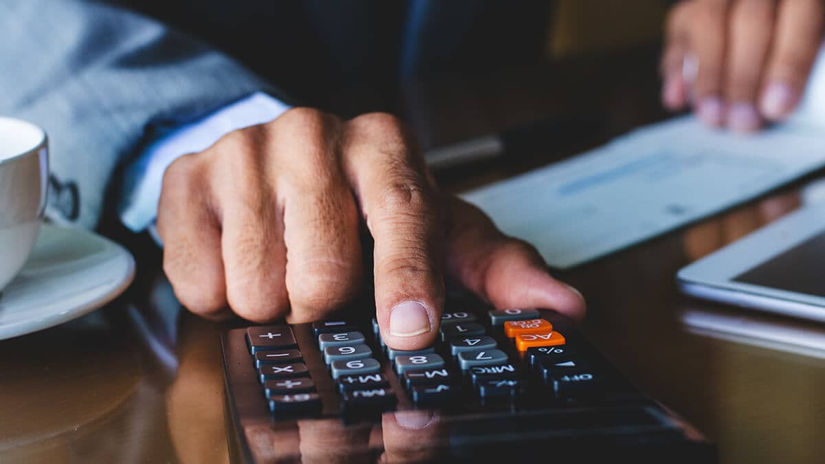 Man calculating payroll taxes with calculator.