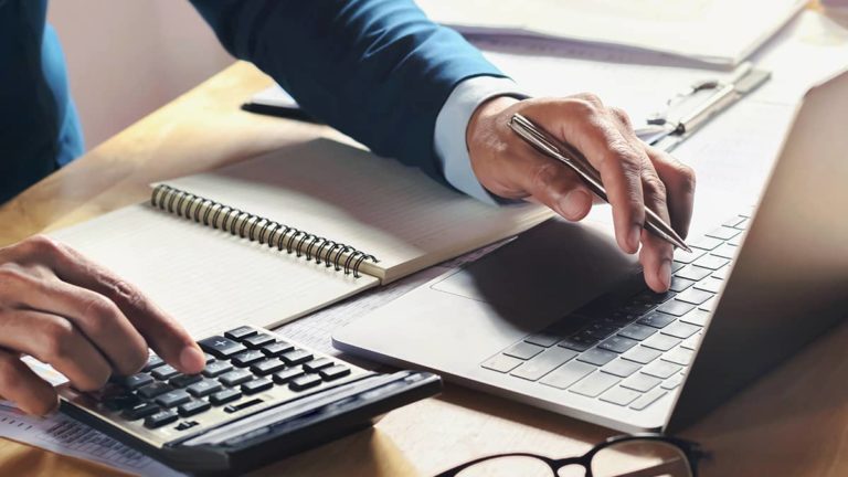 Business owner running payroll on laptop.