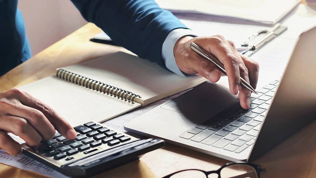 Business owner running payroll on laptop.