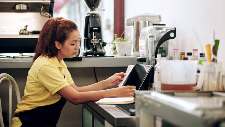 Barista in apron reviewing a receipt.