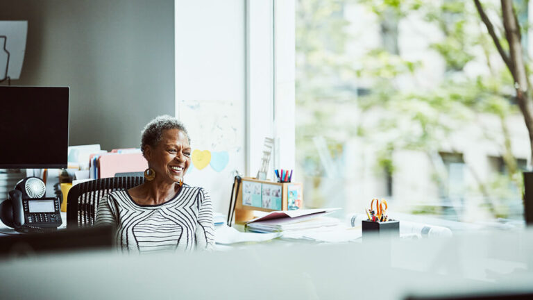 Older woman smiling and looking off into the distance.