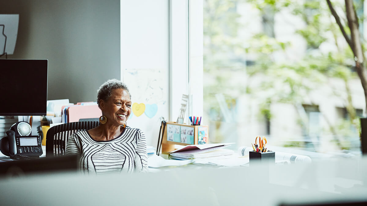 Older woman smiling and looking off into the distance.