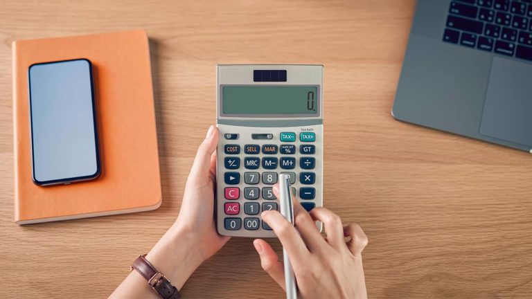 Hands holding a calculator at a desk.