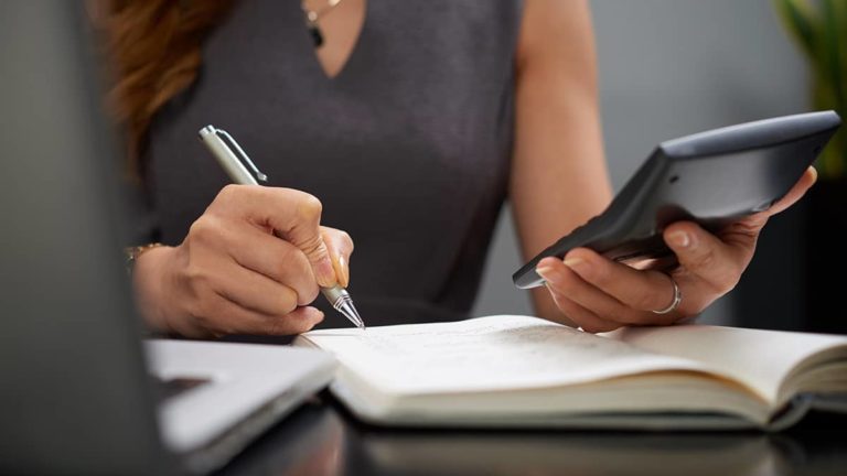 Woman recording inventory journal entry.