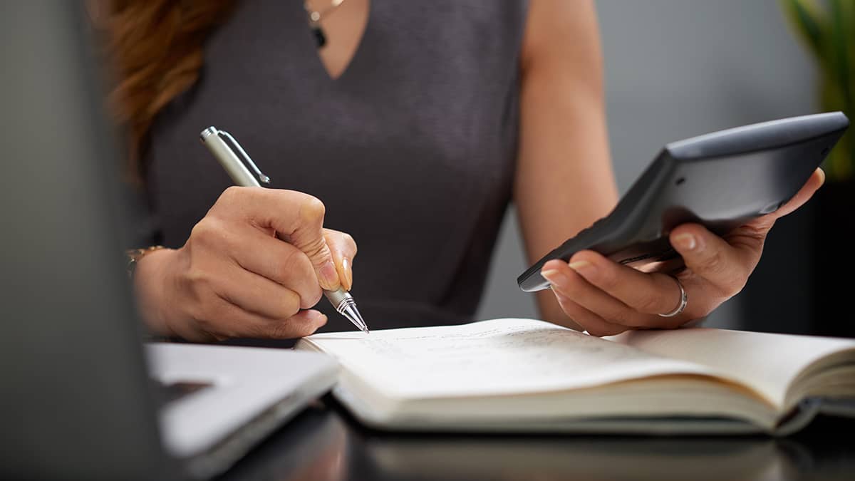 Woman recording inventory journal entry.