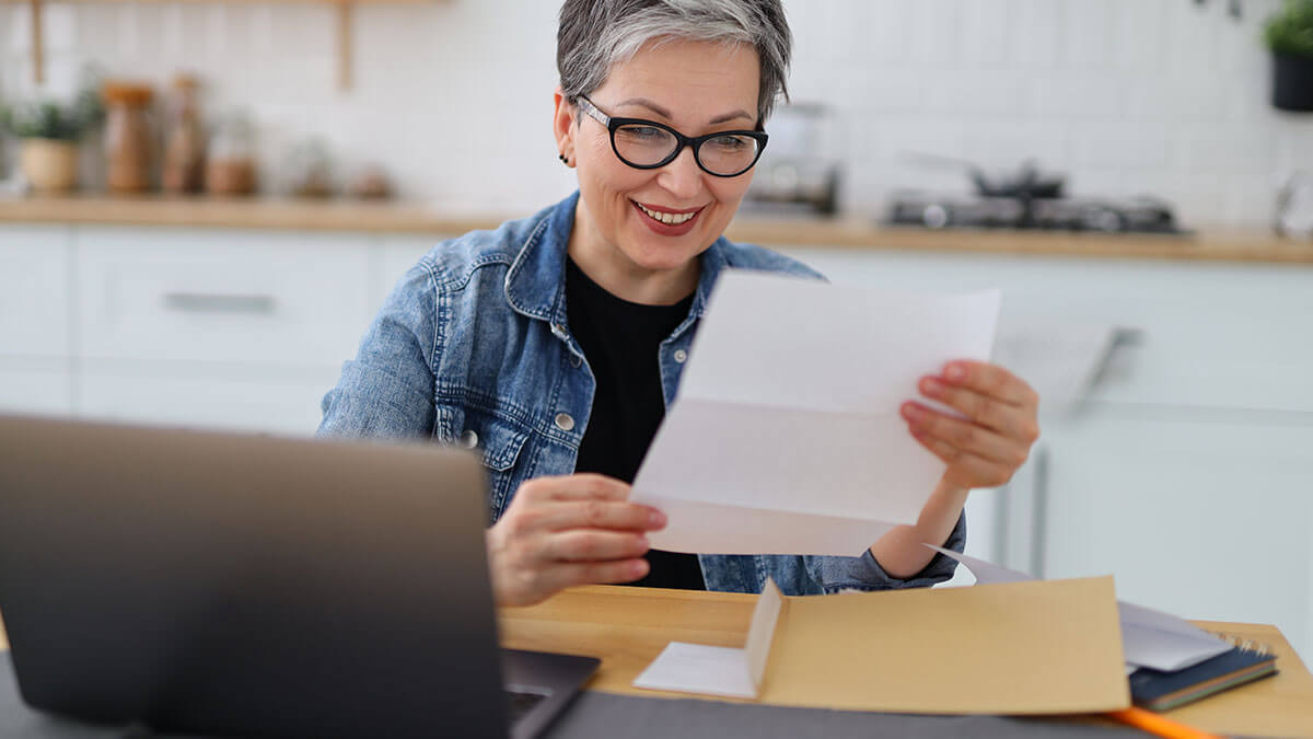 Woman smiling at a piece of paper with her company's assigned EIN.