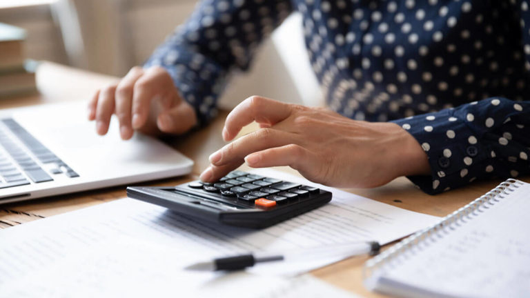 Woman calculating leverage ratios.