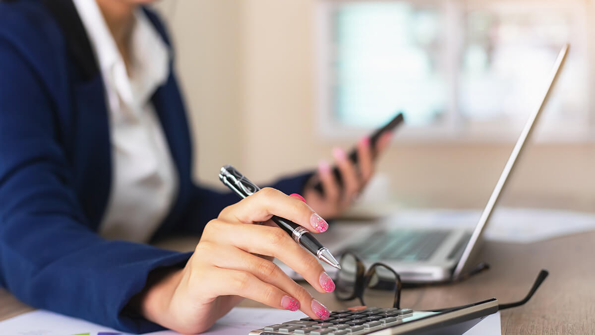 Woman using a cell phone and laptop.