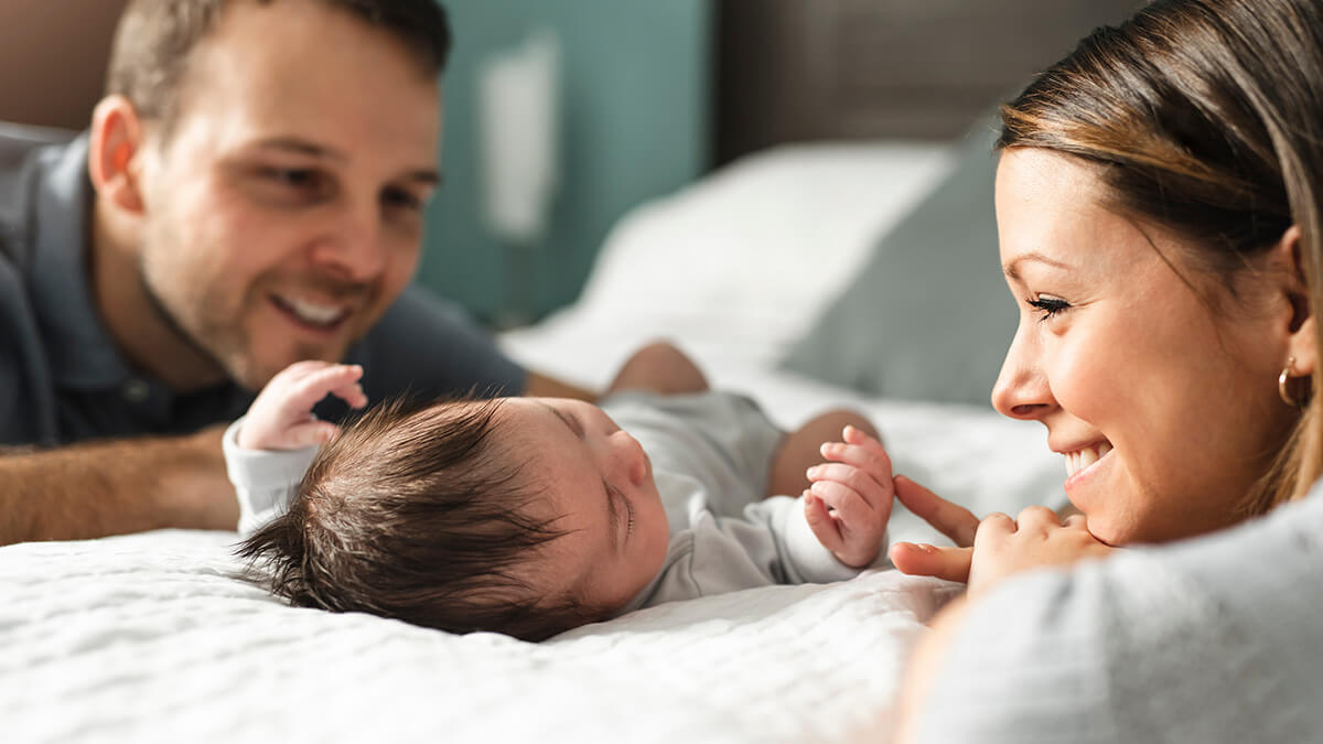 New parents smiling at their baby.
