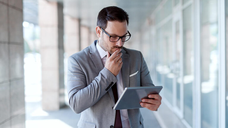 Man reviewing negative cash flow documents on tablet.