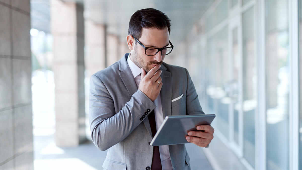 Man reviewing negative cash flow documents on tablet.