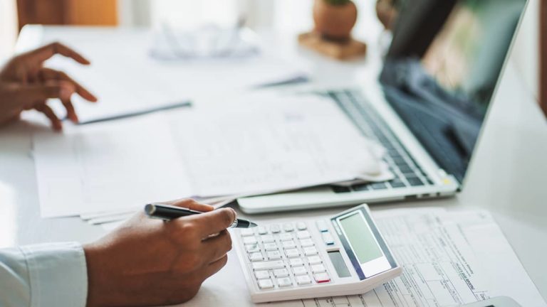 Woman using a calculator at a desk.