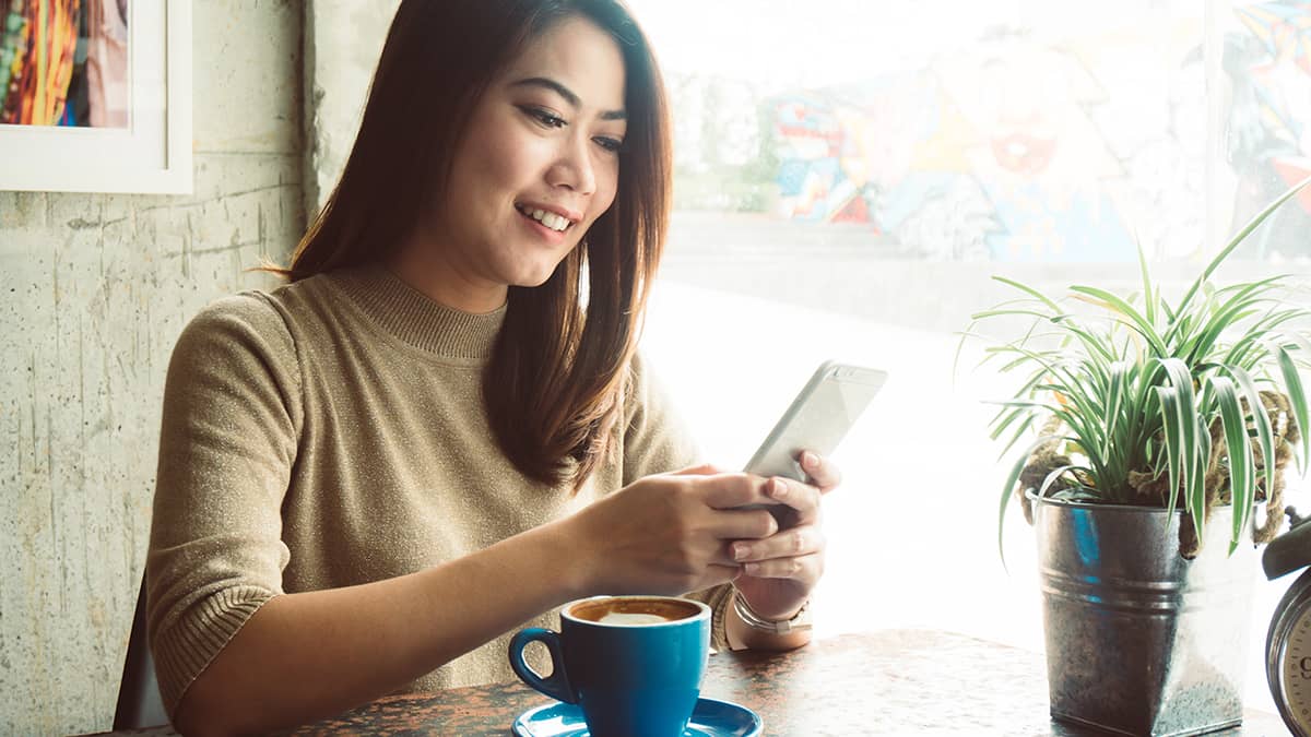 Smiling woman using cell phone.