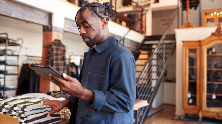 Retail store owner looking at a tablet.