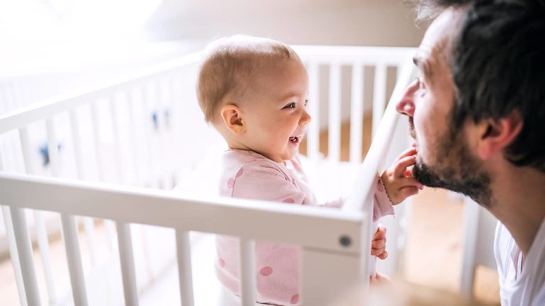 Baby playing with dad's face.