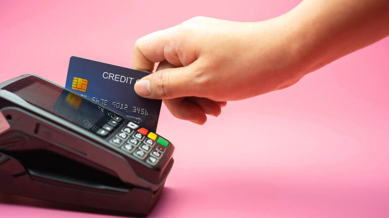 Consumer swiping a credit card through a machine reader.