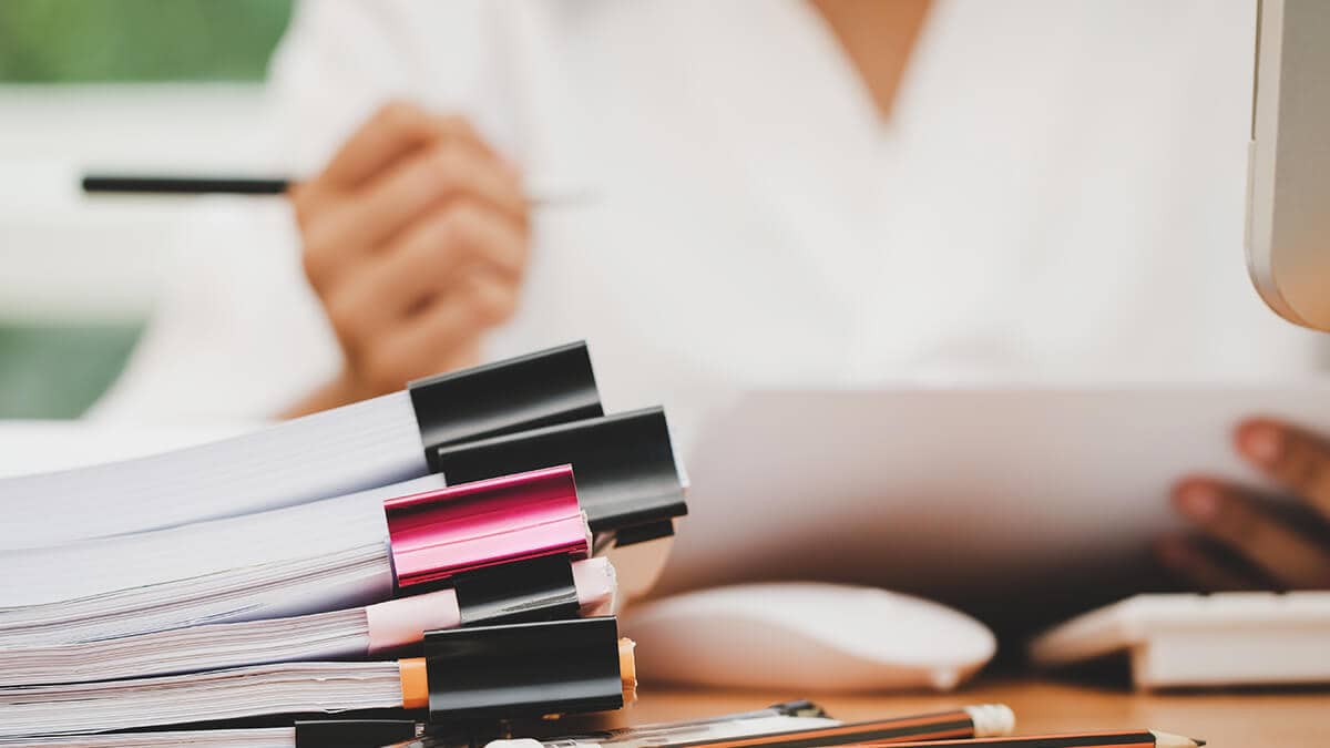 Employer going through a stack of payroll reports.