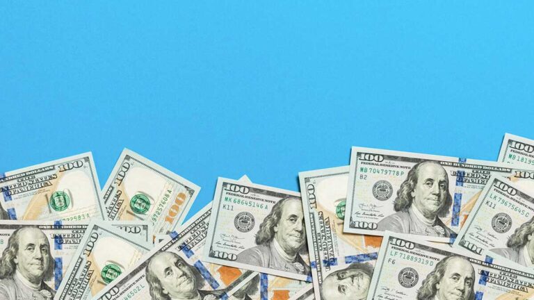$100 bills on a blue background.