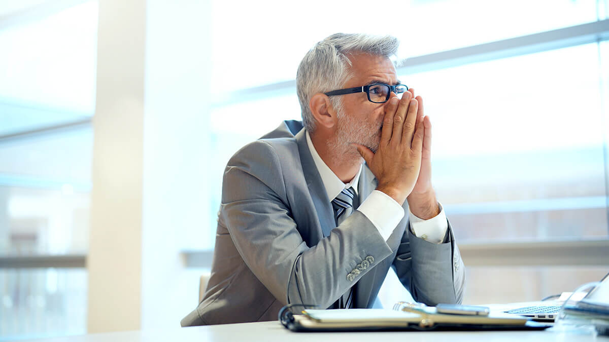 Man with his hands to his face.